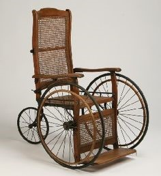 Invalidní vozík z 19. století vyrobený ze dřeva a proutí.